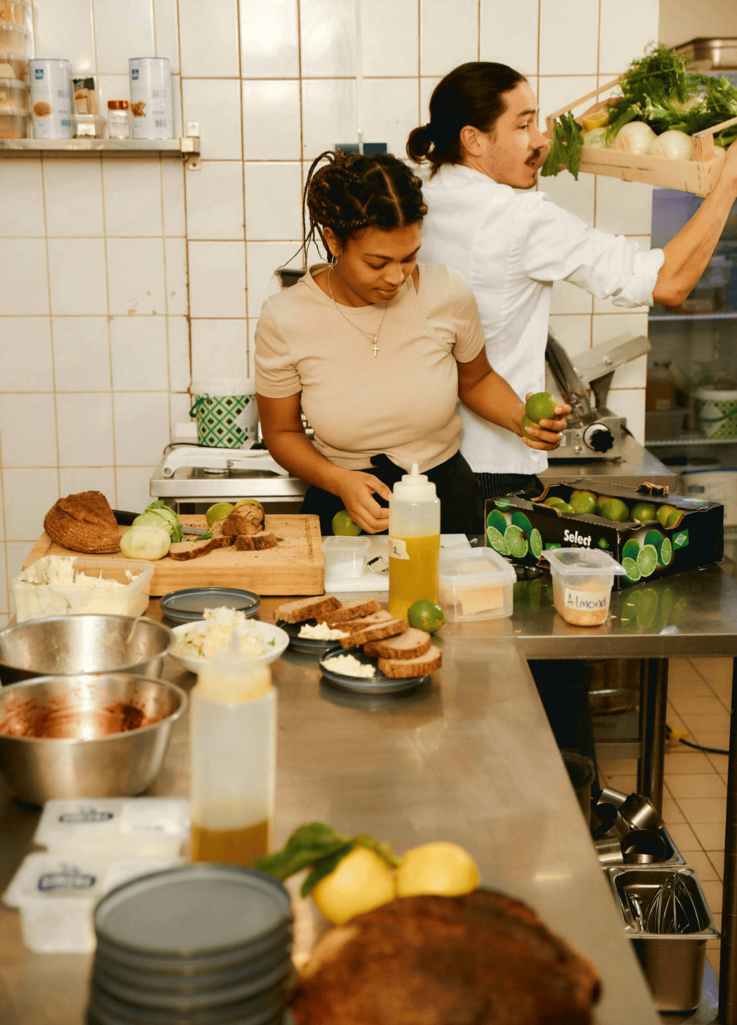 Restaurant staff preparing ingredients in a working kitchen.